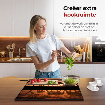 Mujer en la cocina preparando comida con la ayuda del protector de inducción elefantes.