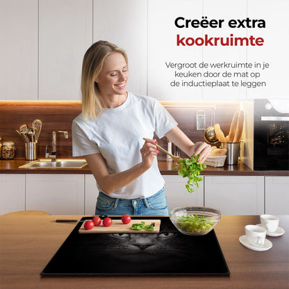 Mujer en la cocina preparando comida con la ayuda del protector de inducción para gatos.